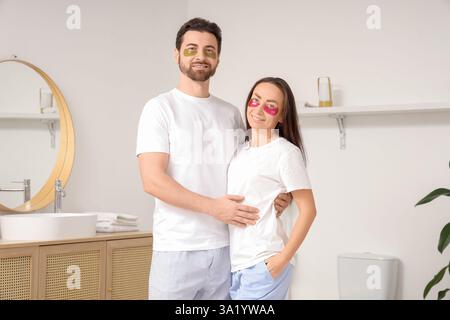 Couple aimant avec des patchs sous les yeux serrés dans la salle de bains Banque D'Images