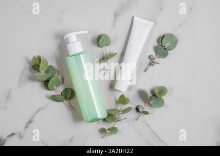 Ensemble de soins cosmétiques de la peau avec extrait d'eucalyptus sur fond de marbre. Maquette d'emballage de gel nettoyant pour le visage et de crème. Banque D'Images
