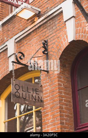Victoria, Canada - 11 juin 2021 : gros plan d'une devanture de magasin à Victoria avec une enseigne suspendue « Ollie Quinn » avec support en fer forgé monté sur un R Banque D'Images