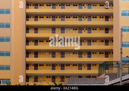 Façade symétrique d'un immeuble d'appartements moderne avec balcons et portes répétitifs Banque D'Images