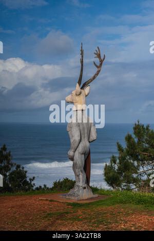 Statue à tête de cerf, nommée Veado, surplombant la plage de Praia do Norte, créée par la sculptrice portugaise Adalia Alberto pour honorer également la légende du Nazaré Banque D'Images