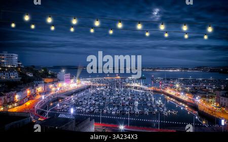 GB - DEVON : vue de nuit sur la baie de Tor avec Torquay Harbour au premier plan et Paignton en arrière-plan (photographie par Edmund Nagele FRPS) Banque D'Images