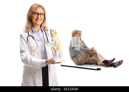 Homme âgé souffrant de douleurs au genou et médecin orthopédique féminin tenant un modèle osseux de genou isolé sur fond blanc Banque D'Images