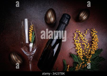 Composition festive de champagne de Pâques avec mimosa et œufs Banque D'Images