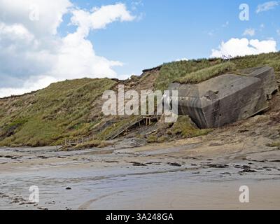 Un vieux bunker glisse des dunes sur la plage sur la côte danoise de la mer du Nord en raison de l'érosion Banque D'Images
