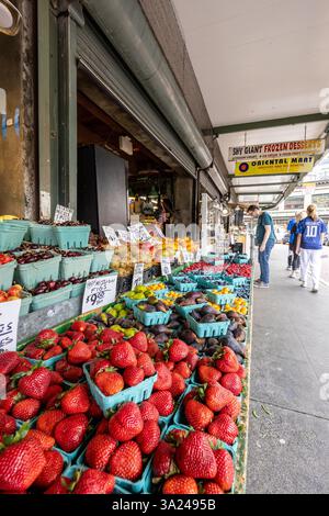 Les acheteurs flânent des fruits frais dans un étal de marché, peut-être Pike place Market, à la recherche d'un régal savoureux. Banque D'Images