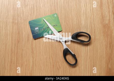 Carte de crédit et ciseaux sur table en bois, vue de dessus Banque D'Images