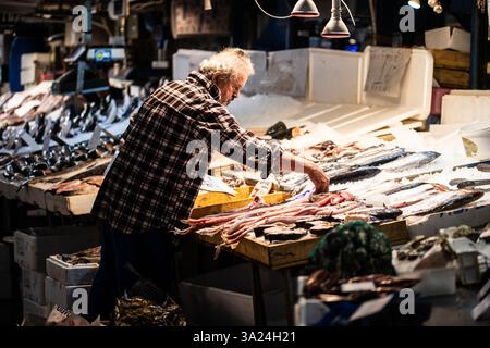 Un homme préparant du poisson pour la vente au marché central d'Athènes, Grèce Banque D'Images