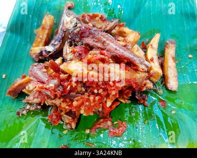 Minangkabau Teri Kentang balado indonésien ou anchois séchés frits et pommes de terre au piment rouge sambal balado, servis sur une feuille de banane. Banque D'Images