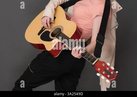 Guitariste femme méconnaissable jouant sa guitare acoustique espagnole à six cordes et appréciant un instrument à cordes strumming lors de sa performance sur scène Banque D'Images