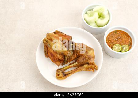 Ayam Goreng ou poulet frit avec sambal et concombre, nourriture indonésienne Banque D'Images