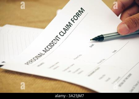 Stylo à main remplissant les détails du formulaire de réclamation personnelle en cas d'accident Banque D'Images