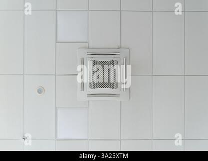 Vue de bas en haut d'un climatiseur de plafond de type cassette pour les grandes pièces installées sur un plafond suspendu. Système HVAC Banque D'Images