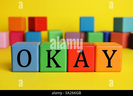 Cubes colorés avec le mot Okay sur fond jaune Banque D'Images