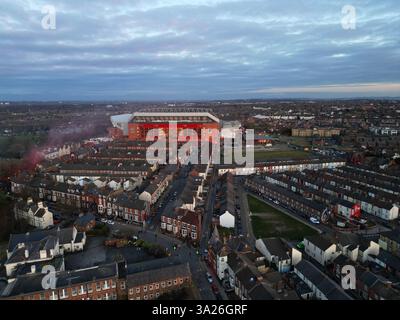 Vue aérienne en début de soirée du stade Anfield, stade du Liverpool FC, lumineux au milieu des rues résidentielles environnantes. Banque D'Images