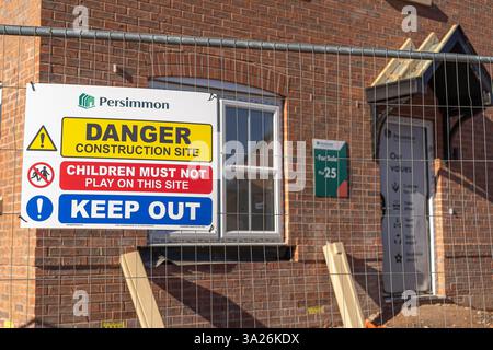 Les constructeurs de maisons de kaki signent sur une clôture de chantier expliquant qu'il s'agit d'un danger, la zone du chantier de construction et de se tenir à l'écart. Banque D'Images