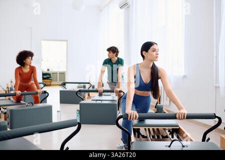 Groupe de personnes participant activement à un cours de pilates, mettant en valeur la force et la concentration. Banque D'Images