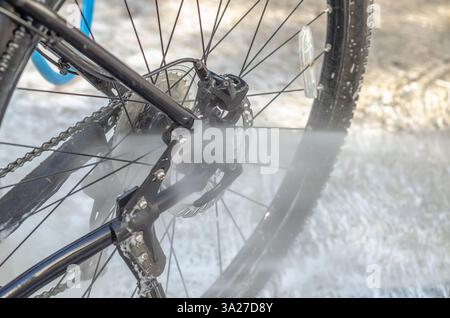 Laver un vélo dans un lave-auto avec un jet d'eau Banque D'Images