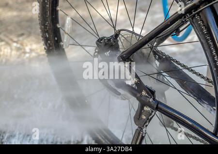 Laver un vélo dans un lave-auto avec un jet d'eau Banque D'Images
