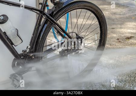 Laver un vélo dans un lave-auto avec un jet d'eau Banque D'Images
