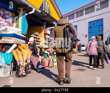 Kiev, Ukraine - 5 mars 2025 : la vie du marché dynamique se déroule alors que les habitants se promènent dans les étals remplis de produits colorés. Le soleil lumineux du printemps projette liv Banque D'Images