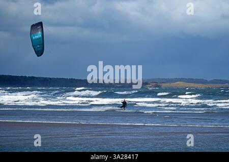 Dunbar, Royaume-Uni. 12 mars 2025. Un Kite surfer dans la baie de Belhaven près de Dunbar à l'extérieur d'Édimbourg, profite des vents violents du mercredi 12 mars 2025. Crédit image météo Royaume-Uni : Rob Gray/Alamy Live News Banque D'Images