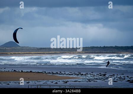 Dunbar, Royaume-Uni. 12 mars 2025. Un Kite surfer dans la baie de Belhaven près de Dunbar à l'extérieur d'Édimbourg, profite des vents violents du mercredi 12 mars 2025. Crédit image météo Royaume-Uni : Rob Gray/Alamy Live News Banque D'Images