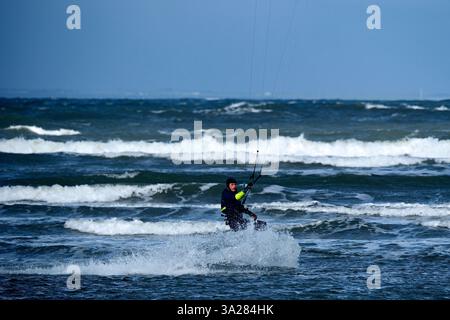 Dunbar, Royaume-Uni. 12 mars 2025. Un Kite surfer dans la baie de Belhaven près de Dunbar à l'extérieur d'Édimbourg, profite des vents violents du mercredi 12 mars 2025. Crédit image météo Royaume-Uni : Rob Gray/Alamy Live News Banque D'Images