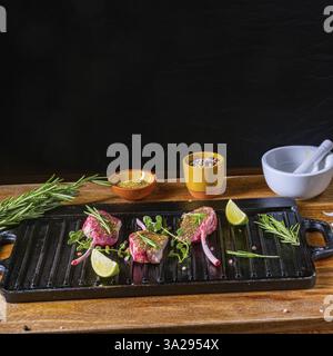 Côtelettes d'agneau crues assaisonnées et marinées aux herbes Banque D'Images