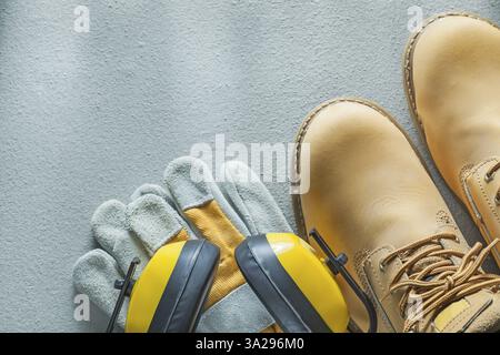 Bottes de dentelle de sécurité gants protecteurs d'oreilles sur fond de béton Banque D'Images