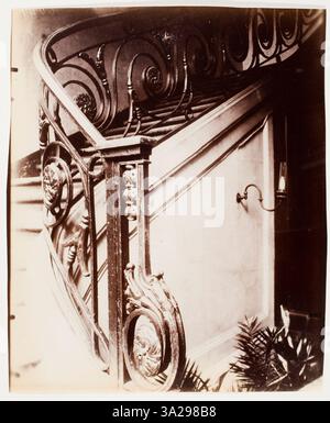 Dans cette photographie, Eugène Atget capture l'escalier détaillé du 8 rue Saint-Augustin, illustrant le style architectural français classique de l'époque. Banque D'Images