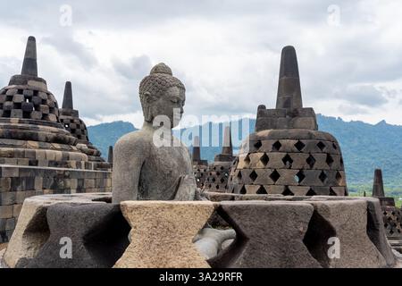 Une statue de Bouddha en pierre dans le temple Borobudur dans le centre de Java, Indonésie. Borobudur Temple est le plus grand temple bouddhiste dans le monde. Banque D'Images