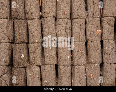 Vue rapprochée d'une section d'un mur de briques en adobe mal construit, dans une maison de la ville coloniale de Villa de Leyva, dans le centre de la Colombie. Banque D'Images
