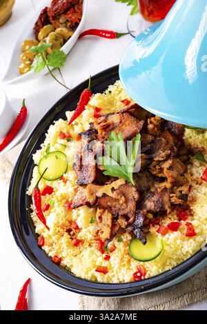 Tajin avec couscous, légumes et viande sur fond blanc Banque D'Images