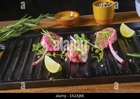 Côtelettes d'agneau crues assaisonnées et marinées aux herbes Banque D'Images