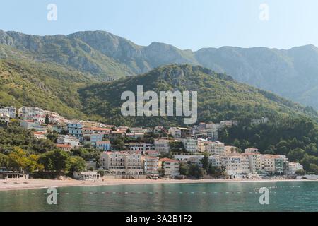 Une vue sur l'eau sur Sveti Stefan, Budva, une ville pittoresque sur la côte adriatique du Monténégro, avec de superbes montagnes en arrière-plan Banque D'Images