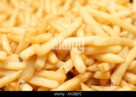 Vue rapprochée de délicieuses frites ou frites chaudes assaisonnées dorées. Envie de nourriture, habitudes alimentaires malsaines ou repas traditionnel à emporter. À emporter traditionnel Banque D'Images
