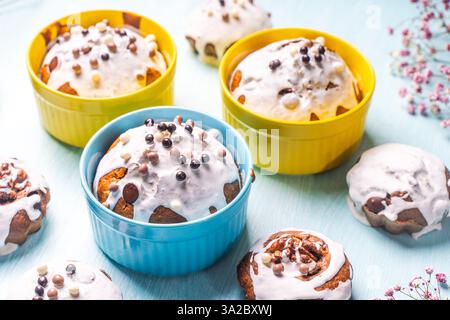 Cupcakes et muffins ou gâteaux de Pâques versés avec glaçage blanc sur une table bleu clair. Espace pour le texte. Vue de dessus. Photo de haute qualité Banque D'Images