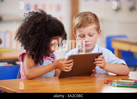 Salle de classe, tablette et enfants apprenant ensemble, étudiant et éduquant en préscolaire. Étudiants, technologie et enfants en ligne pour le développement, puzzle Banque D'Images