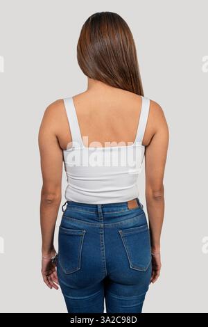 Photo studio d'une jeune femme portant un débardeur blanc et un Jean, mettant en valeur la vue arrière Banque D'Images