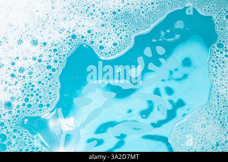 Bulles de détergent moussant et eau turquoise. Fond de texture. Banque D'Images