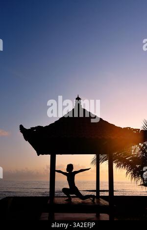 Femme faisant du yoga le matin avec vue sur l'océan Indien, l'Indonésie, Bali, Nusa Penida, Karangsari Banque D'Images