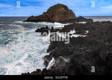 Côte rocheuse par temps orageux sur la côte nord-ouest près de Porto Moniz, petite île au large Ilheu mole, Portugal, Madère Banque D'Images