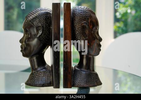 Têtes en bois sculptées de personnes africaines faites comme serre-livres Banque D'Images