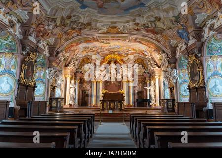 Magnifique intérieur de l'église baroque avec fresques au plafond richement décorées, détails d'or complexes, sculptures ornées. Banque D'Images