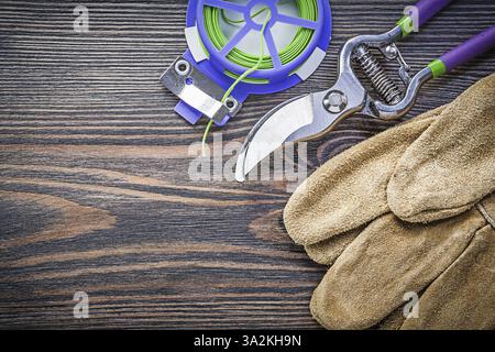 Sécateurs tranchants gants de sécurité Soft Twist cravate sur le concept d'agriculture de planche en bois Banque D'Images