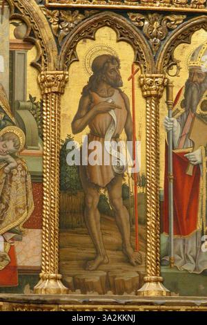 Dans cette œuvre, Carlo et Vittore Crivelli dépeignent Saint Jean Baptiste, soulignant sa signification spirituelle par des couleurs vives et une exécution détaillée. Banque D'Images