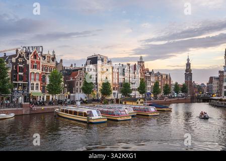 Amsterdam, pays-Bas - 23 juin 2022 : architecture traditionnelle le long de la rue Amstel au crépuscule. Banque D'Images