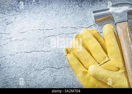 Ensemble de gants de sécurité en cuir marteau à griffe sur le concept de construction de fond métallique Banque D'Images