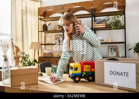 Une jeune femme trie des vêtements et des jouets sur appel, promouvant la durabilité. Banque D'Images